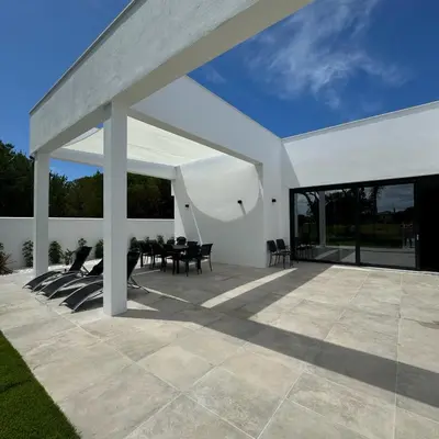 a white pavilion with a table on a patio at Poniente Beach House in Chiclana de la Frontera