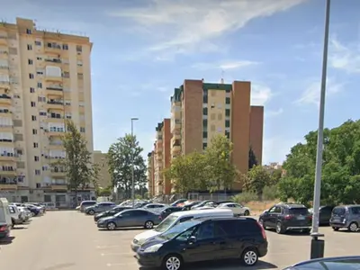 a parking lot with cars parked in front of tall buildings at Apartamento 3 Dormitorios con Terraza in Jerez de la Frontera