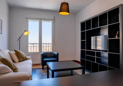 a living room with a couch and a table at Ático Plaza Del Cabildo A 10 Min De La Playa in Sanlúcar de Barrameda