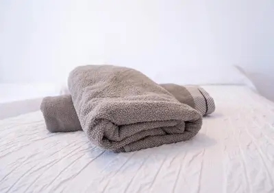 a towel sitting on top of a bed at Ático Plaza Del Cabildo A 10 Min De La Playa in Sanlúcar de Barrameda