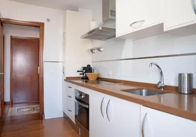 a kitchen with white cabinets and a sink at Ático Plaza Del Cabildo A 10 Min De La Playa in Sanlúcar de Barrameda