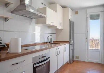 a white kitchen with a sink and a refrigerator at Ático Plaza Del Cabildo A 10 Min De La Playa in Sanlúcar de Barrameda