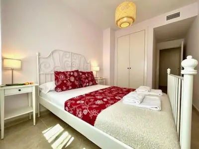a white bed with red pillows in a bedroom at GATU Ático Divino 