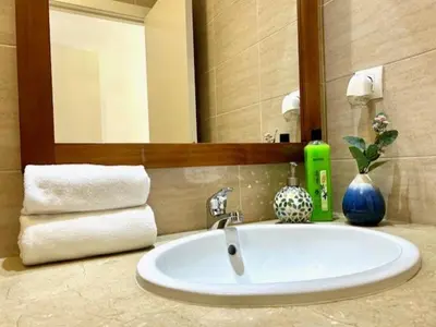 a bathroom with a sink and a mirror and towels at GATU Ático Divino 