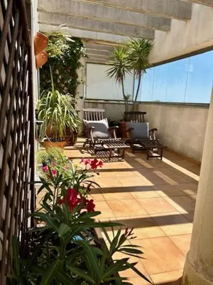 a patio with chairs and flowers on a balcony at GATU Ático Divino 