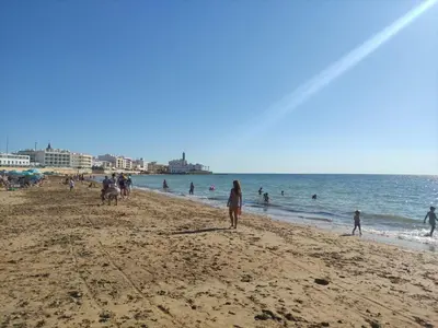 a group of people walking on the beach at La Longuera - Playa Cruz del Mar in Chipiona