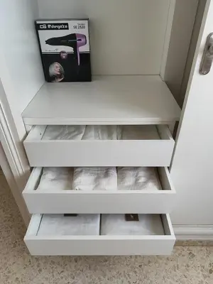 a closet with white drawers and a magazine at La Longuera - Playa Cruz del Mar in Chipiona