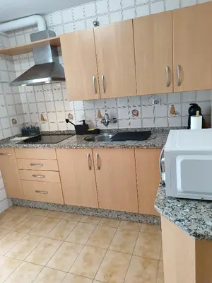 a kitchen with wooden cabinets and a sink at La Longuera - Playa Cruz del Mar in Chipiona