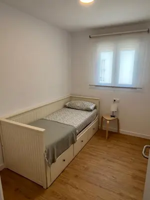 a white bedroom with a bed and a window at Apartamento Chiclana de la frontera in Chiclana de la Frontera