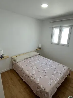 a bedroom with a bed in a room with two windows at Apartamento Chiclana de la frontera in Chiclana de la Frontera