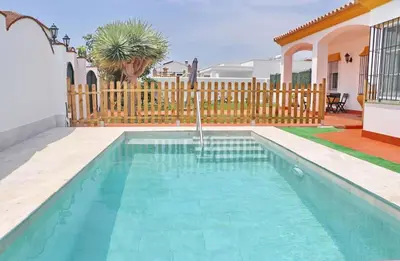 a swimming pool in the backyard of a house at Casa Pradillo in Conil de la Frontera