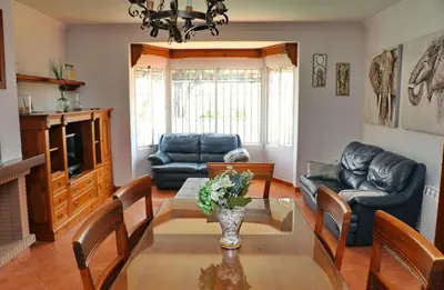 a living room with a table and leather furniture at Casa Pradillo in Conil de la Frontera