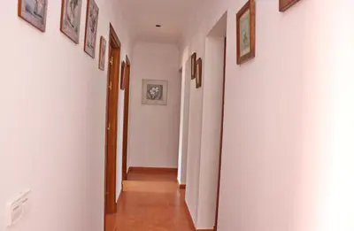 a hallway with white walls and pictures on the walls at Casa Pradillo in Conil de la Frontera
