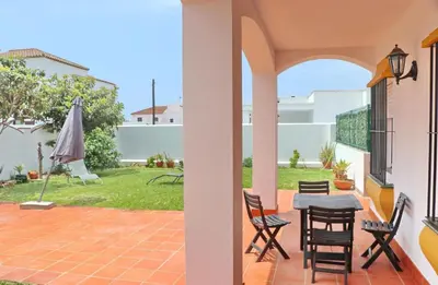 a patio with a table and chairs and an umbrella at Casa Pradillo in Conil de la Frontera