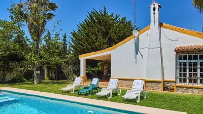 a church with chairs next to a swimming pool at Villa Alegría Conil de la Frontera by Ruralidays in Conil de la Frontera