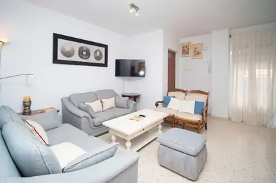 a living room with two couches and a table at Piso Ángel in Sanlúcar de Barrameda
