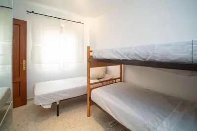 a bedroom with two bunk beds and a window at Piso Ángel in Sanlúcar de Barrameda