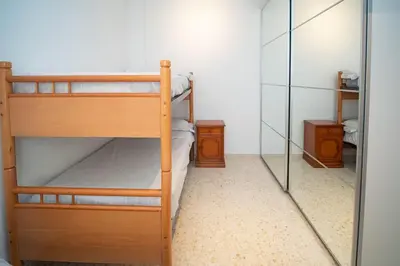 a bedroom with two bunk beds and a mirror at Piso Ángel in Sanlúcar de Barrameda