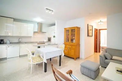a kitchen and living room with a table and a couch at Piso Ángel in Sanlúcar de Barrameda