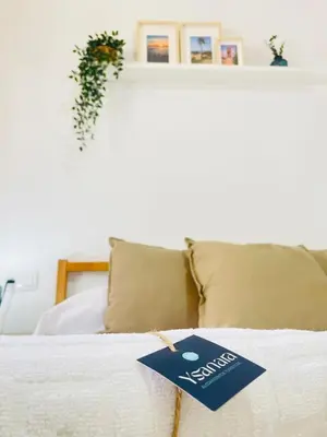 a sign on top of a bed with pillows at Entre Pinos in Chiclana de la Frontera