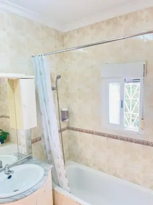 a bathroom with a tub and a sink and a shower at Entre Pinos in Chiclana de la Frontera