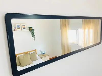 a mirror reflection of a bed in a room at Entre Pinos in Chiclana de la Frontera