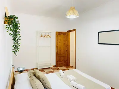 a bedroom with a bed and a potted plant at Entre Pinos in Chiclana de la Frontera