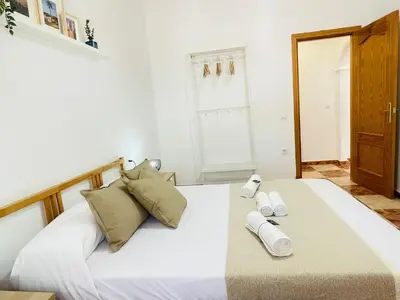 a bedroom with a large white bed with towels on it at Entre Pinos in Chiclana de la Frontera