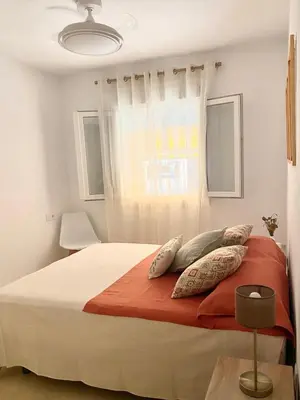 a bedroom with a bed with pillows and a window at Novo Sancti Petri LUZ DEL NOVO in Novo Sancti Petri