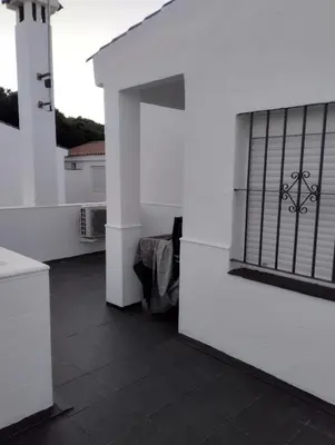 a white building with a window with bars on it at Duplex Las Torres a 700m Playa in Chiclana de la Frontera