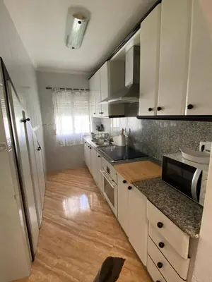 a living room with a table and a blue couch at Duplex Las Torres a 700m Playa in Chiclana de la Frontera