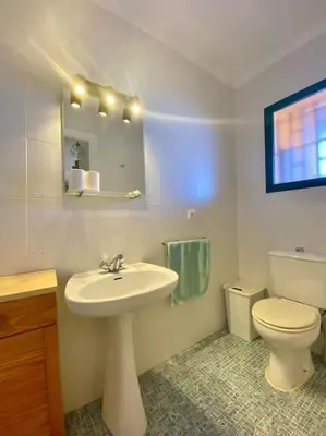 a bathroom with a white sink and a toilet at Amplio adosado a pocos metros de la playa in Poblado de Sancti Petri