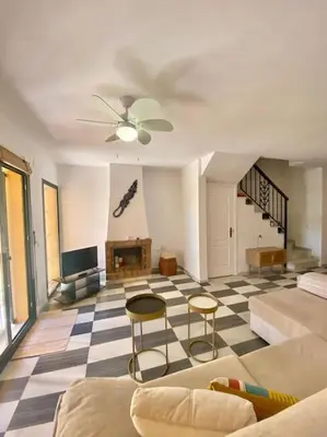 a living room with a ceiling fan and a couch at Amplio adosado a pocos metros de la playa in Poblado de Sancti Petri