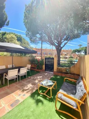 a patio with a couch and chairs and a table at Amplio adosado a pocos metros de la playa in Poblado de Sancti Petri