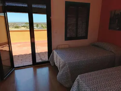 a bedroom with two beds and a view of a field at Amplio adosado a pocos metros de la playa in Poblado de Sancti Petri