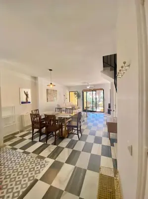 a living room with a table and a dining room at Amplio adosado a pocos metros de la playa in Poblado de Sancti Petri