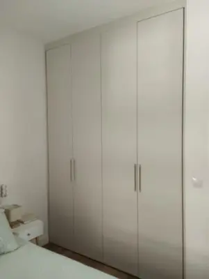 a white bedroom with white cabinets and a bed at Apartamento Cata in El Puerto de Santa María