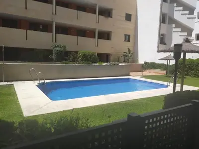 a swimming pool in a yard next to a building at Apartamento Cata in El Puerto de Santa María