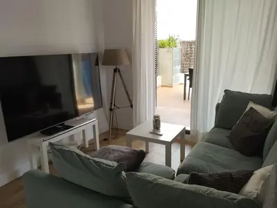 a living room with a couch and a flat screen tv at Apartamento Cata in El Puerto de Santa María
