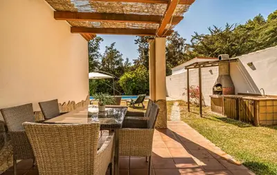 a patio with a table and chairs and a grill at Nice Home In Chiclana De La Fronter in Novo Sancti Petri