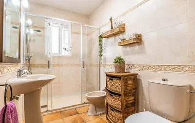 a bathroom with a toilet and a sink and a shower at Nice Home In Chiclana De La Fronter in Novo Sancti Petri