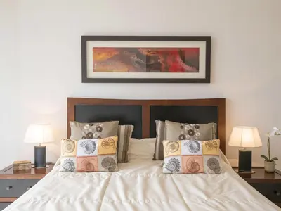 a bedroom with a bed with pillows and two lamps at Holiday Home Arcos Gardens Golf by Interhome in Arcos de la Frontera