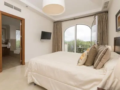 a bedroom with a large white bed with a window at Holiday Home Arcos Gardens Golf by Interhome in Arcos de la Frontera