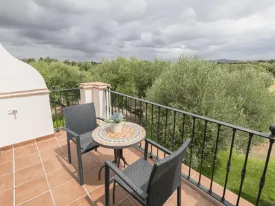 a patio with two chairs and a table on a balcony at Holiday Home Arcos Gardens Golf by Interhome in Arcos de la Frontera