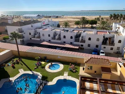 an aerial view of a resort with a pool and the beach at Apartamento Mirador del Coto in Sanlúcar de Barrameda