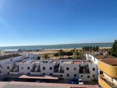 a view of the beach from the balcony of a resort at Apartamento Mirador del Coto in Sanlúcar de Barrameda