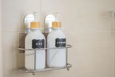 three bottles of soap on a shelf in a bathroom at Apartamento Rosole in Sanlúcar de Barrameda