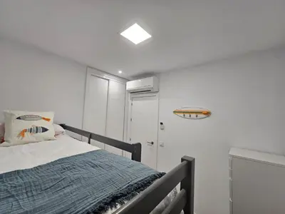 a bedroom with a bed and a white wall at Casa en La Barrosa vista mar in Chiclana de la Frontera