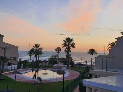 a view of the ocean from a resort at sunset at Casa en La Barrosa vista mar in Chiclana de la Frontera