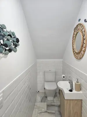 a bathroom with a white toilet and a sink at Casa en La Barrosa vista mar in Chiclana de la Frontera
